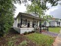 Charming home with inviting front porch, black railings, and a brick and gravel pathway to the front doors at 31 N Broad N St, Porterdale, GA 30014
