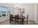 Bright dining area featuring a chandelier, table and chairs, and a large window at 5133 Greenard Watson Lane, Buford, GA 30518