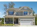 Inviting two-story home with stone accents, covered front porch, and attached two-car garage at 2599 Windsor Knoll Dr, Dacula, GA 30019