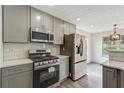 Modern kitchen featuring stainless steel appliances and gray cabinets at 539 Easton Dr, Locust Grove, GA 30248