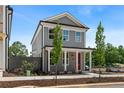 A charming two-story home with gray siding, white trim, a front porch and a bright red front door at 40 Spirea Way, Auburn, GA 30011