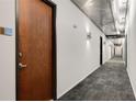 Contemporary hallway featuring gray carpet, modern lighting, and doors to various units at 130 Arizona Ne Ave # 104, Atlanta, GA 30307