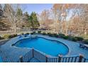 Inviting kidney-shaped pool with a stone patio and water feature at 6740 Mountain Lake Ln, Cumming, GA 30028