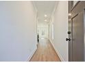 Bright hallway with hardwood floors and white walls, leading to a sunlit living area at 685 Sunstone Ln, Lawrenceville, GA 30043