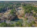 Aerial view of house and pond on a wooded lot at 595 S Mount Carmel Rd, Mcdonough, GA 30253