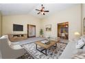 Open living room featuring vaulted ceiling, fan, tv, and access to dining area at 254 Cobblestone Ln, Mcdonough, GA 30252