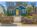 Charming blue bungalow featuring a bright yellow front door and a quaint white picket fence at 1196 Oleander Nw St, Atlanta, GA 30314