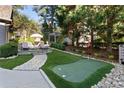 Landscaped backyard featuring a putting green and stone pathway at 6220 Vickery Creek Rd, Cumming, GA 30040