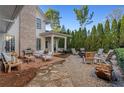 Relaxing backyard featuring stone hardscape, outdoor seating, and manicured landscaping at 6830 Vickery Creek Rd, Cumming, GA 30040