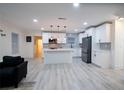 Modern kitchen with white cabinets, island, stainless steel appliances, and gray backsplash at 1330 Lockwood Sw Dr, Atlanta, GA 30311