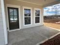 Covered porch featuring a glass-paneled front door and large windows offering a view of the surrounding landscape at 2116 Boxwood Se Cir, Conyers, GA 30094