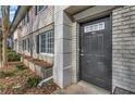Charming townhome entrance featuring a dark front door and manicured landscaping along the facade at 6940 Roswell Rd # E12, Atlanta, GA 30328