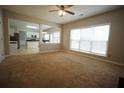 Open living room with carpet flooring, bright windows, and an open view into the kitchen area at 3936 Toccoa Falls Dr, Duluth, GA 30097