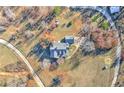 Aerial view of the property showcasing the home, surrounding landscape, and long drive with mature trees and landscaping at 3975 Mcconnell Rd, Cumming, GA 30028