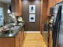 Stylish kitchen featuring stainless appliances, wood cabinets and floors, and granite countertops at 855 Peachtree Ne St # 2306, Atlanta, GA 30308