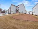 View of the side of townhomes showing a side entrance with two-car garages and landscaped surroundings at 691 Cordele Ln, Sugar Hill, GA 30518
