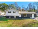 Charming home with a dark gray and white exterior, metal roof, and a well-maintained front yard at 2793 Heritage Ln, Morrow, GA 30260