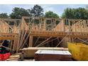 New home construction featuring wood framing with a second story, lumber and a yellow container on the property at 1416 Lucan Ln # Wc220, Lawrenceville, GA 30043