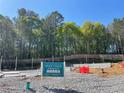 New home construction site featuring a foundation, and wooded backdrop at 1416 Lucan Ln # Wc220, Lawrenceville, GA 30043