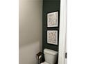 A bathroom showcasing a toilet with decorative abstract wall art and a convenient toilet paper holder at 253 Ivey Ter # 48, Temple, GA 30179