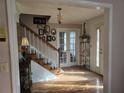 Inviting foyer features hardwood floors, staircase, and natural light streaming through the decorative glass front door at 9031 Par Dr, Douglasville, GA 30134