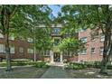 Beautiful brick apartment building surrounded by lush greenery with a landscaped courtyard and entryway at 908 Juniper Ne St # 205, Atlanta, GA 30309