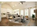 Open living room features vaulted ceilings, a kitchen, and a stone fireplace at 1150 Sweet Mia Ln, Powder Springs, GA 30127