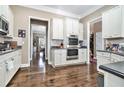 Spacious kitchen with stainless steel appliances, white cabinets, and a view into the dining room at 1120 Constitution Way, Cumming, GA 30040