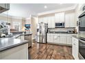 Bright kitchen featuring stainless steel appliances, white cabinets, and hardwood floors at 1120 Constitution Way, Cumming, GA 30040