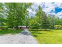 Gravel driveway leading to a charming log cabin in a wooded area at 58 Wesley Chapel Ln, Villa Rica, GA 30180