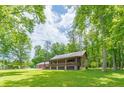 Log cabin home surrounded by lush greenery and large trees at 58 Wesley Chapel Ln, Villa Rica, GA 30180