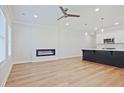 Open-concept living room featuring a modern fireplace, ceiling fan and sleek kitchen with large island at 913 Agate Ln, Lawrenceville, GA 30043