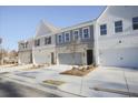 New townhome exteriors with brick and siding, featuring garages, landscaped front yards, and modern architectural design at 909 Agate Ln, Lawrenceville, GA 30043