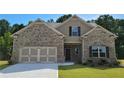 Charming home with brick and siding exterior, attached garage, and well-maintained lawn at 1124 Kingston Hill Dr, Loganville, GA 30052
