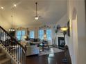 Inviting living room featuring hardwood floors, fireplace, and ample natural light from large windows at 1124 Kingston Hill Dr, Loganville, GA 30052