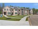 View of newly constructed townhomes with brick exteriors, beautiful lawns, and well-maintained sidewalks at 161 Brush Creek Ct, Stockbridge, GA 30281