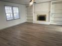 Living room features a brick fireplace, built-in shelves, and wood-look flooring at 1678 Se Christian Cir, Conyers, GA 30013