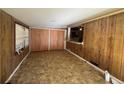 Cozy living room featuring wood paneling, a large window, and access to the kitchen at 4597 Karla Cir, Conley, GA 30288