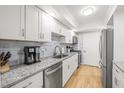 Bright kitchen featuring granite countertops, stainless appliances, and white cabinetry at 6851 Roswell Rd # I18, Sandy Springs, GA 30328