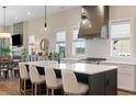 Spacious kitchen featuring a central island, modern lighting, and a sleek stainless steel range hood at 1130 Lupo Loop, Chattahoochee Hills, GA 30268