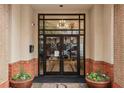 Main entrance with glass doors, brick facade, and flower planters at 230 E Ponce De Leon Ave # 524, Decatur, GA 30030