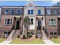 Three-story townhome with brick facade and front yard landscaping at 3157 Moor View Rd # 34, Duluth, GA 30096