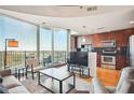 Bright living room featuring hardwood floors, a large window with city views, and a modern kitchen at 361 17Th Nw St # 2208, Atlanta, GA 30363