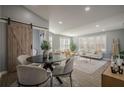 Bright living room with a sliding barn door, light walls, and ample seating offers style and comfort at 4706 Warrior Se Way, Mableton, GA 30126