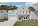 Charming two-story home boasts a lovely front porch, a two-car garage, and neatly manicured lawn at 238 Arnewood Cir, Mcdonough, GA 30253