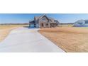 Beautiful modern farmhouse with gray siding, wood accents, and a large driveway on a sunny day at 1422 Alcovy Station Rd, Covington, GA 30014