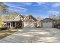 Two-story house exterior with a three-car garage and a separate garage in the backyard at 7042 Confederate Ct, Villa Rica, GA 30116