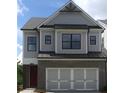 Charming two-story home featuring a brick facade, gray siding, and a three-car garage with decorative carriage hardware at 1059 Crest Mill Dr, Marietta, GA 30008