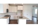 Bright kitchen featuring white cabinets, granite countertops, stainless steel appliances, and an island with a sink at 1059 Crest Mill Dr, Marietta, GA 30008