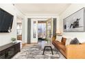 Spacious living room with leather sofa, large TV, and access to private balcony at 266 11Th Ne St # 308, Atlanta, GA 30309